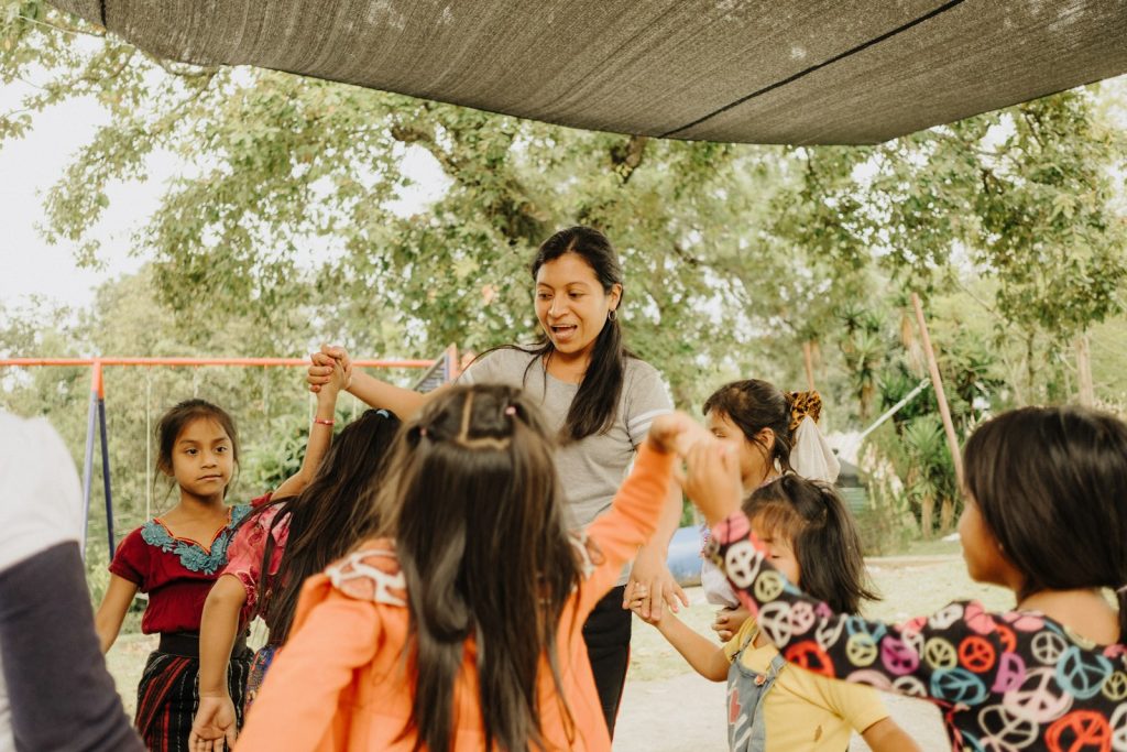 a group of young children standing around each other